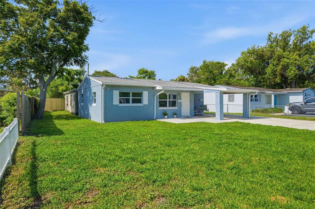 A light blue single-story house with a covered front porch and a large grassy yard — 6252 MASSACHUSETTS AVENUE, NEW PORT RICHEY, FL