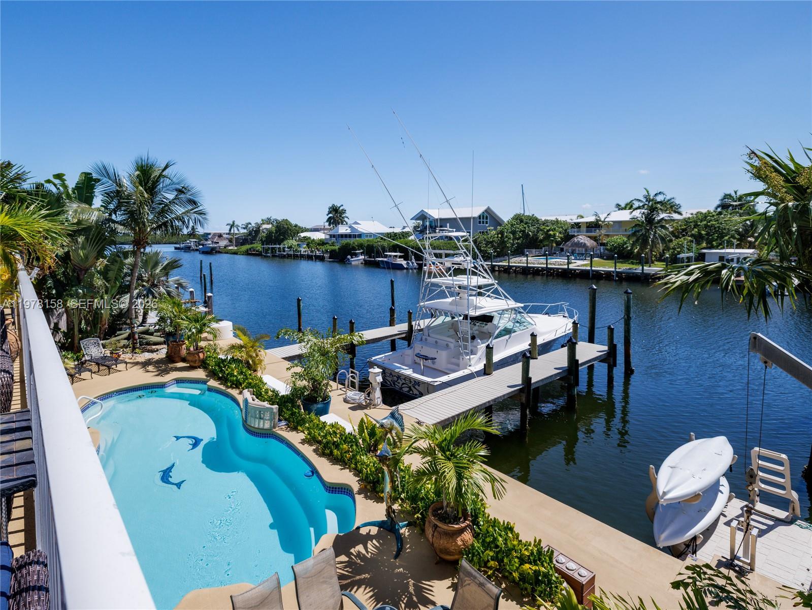 An elevated view shows a swimming pool, a boat docked at a pier, and a canal — 14 Avenue F, Marathon FL 33050, MARATHON, FL