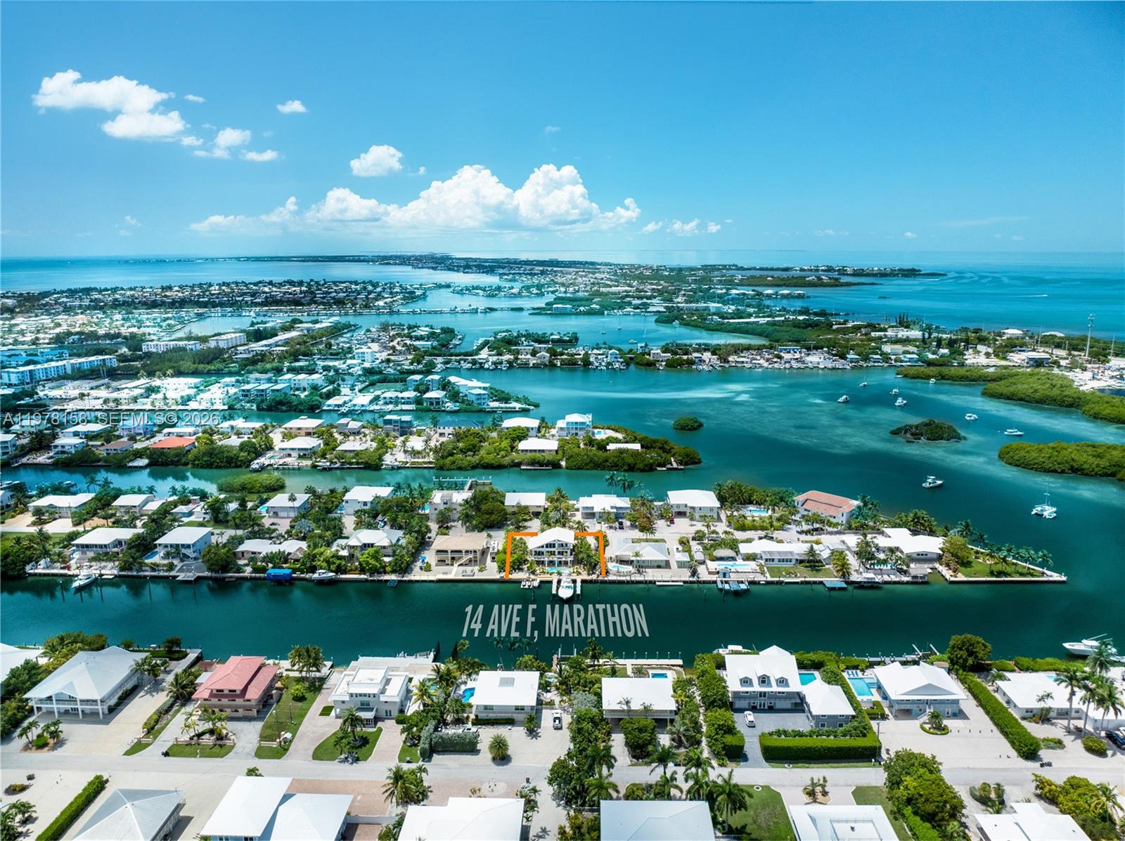 An aerial view shows a waterfront house with a boat dock on a canal — 14 Avenue F, Marathon FL 33050, MARATHON, FL