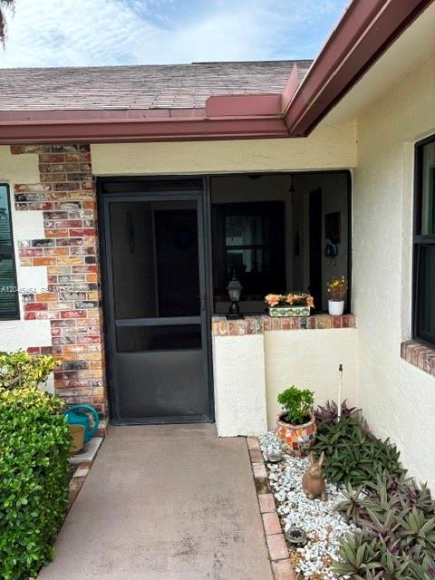 A single-story house with a brown roof, a garage, and palm trees in the yard — 100 S Moccasin Trl S, Jupiter FL 33458, JUPITER, FL