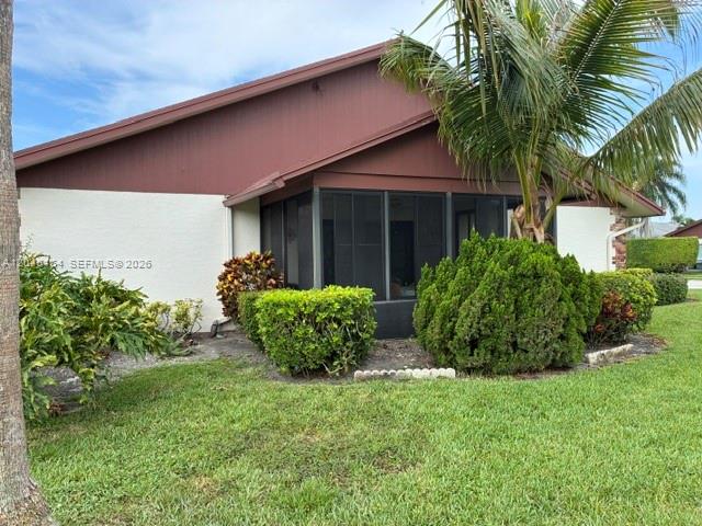 A screen door leads to a covered entryway with a brick wall and potted plants — 100 S Moccasin Trl S, Jupiter FL 33458, JUPITER, FL