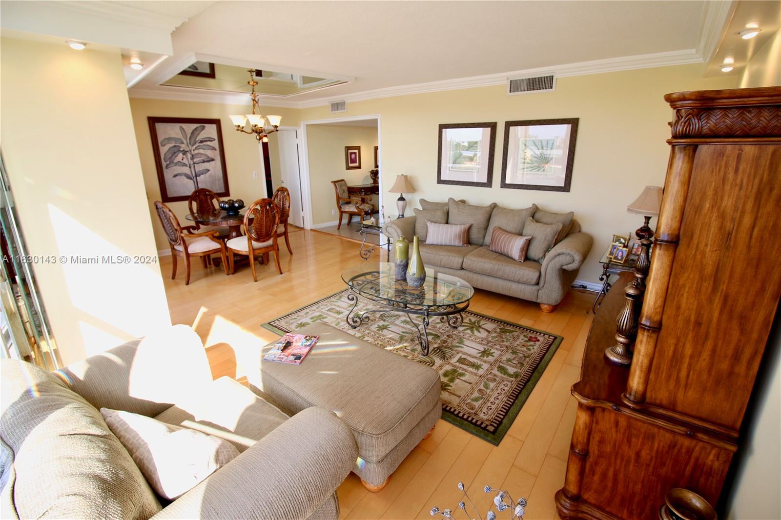 A living room features a beige sofa, glass coffee table, area rug, and dining area — 900 Bay Dr # 319, Miami Beach FL 33141, MIAMI BEACH, FL
