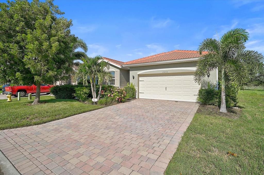 A kitchen with granite countertops and dark wood cabinets opens into a living area — 24200 RIVERFRONT DRIVE, PORT CHARLOTTE, FL