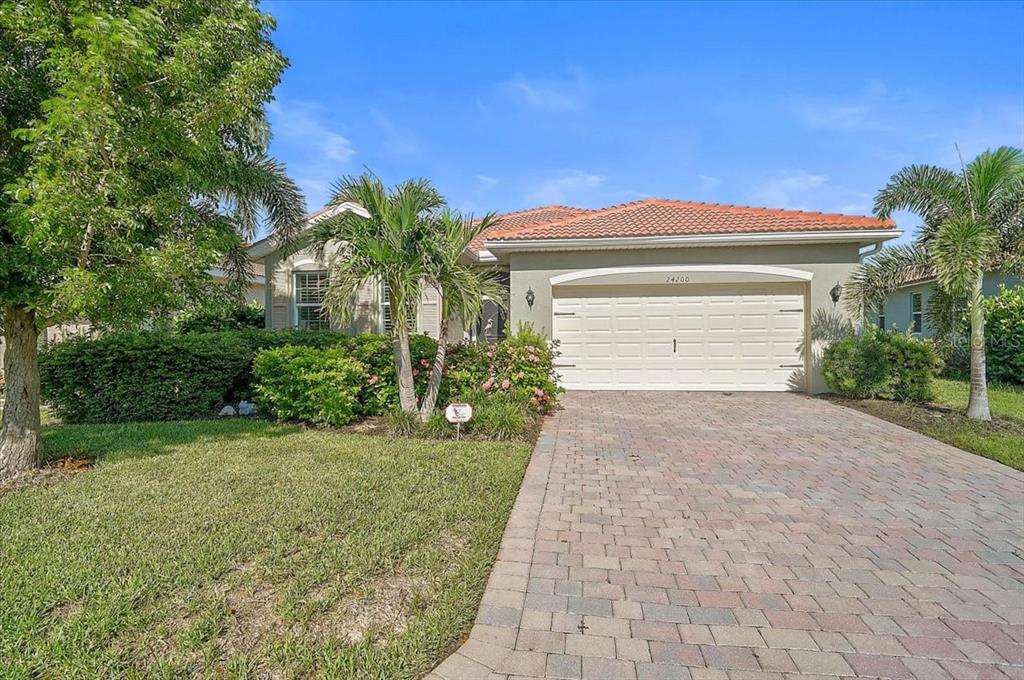A kitchen island with granite countertops overlooks a dining area and a living room — 24200 RIVERFRONT DRIVE, PORT CHARLOTTE, FL