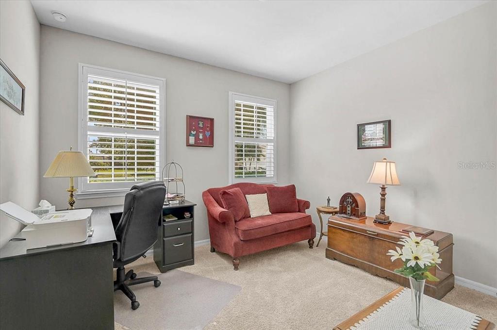 A kitchen with brown cabinets, granite countertops, and a sofa placed against the island — 24200 RIVERFRONT DRIVE, PORT CHARLOTTE, FL