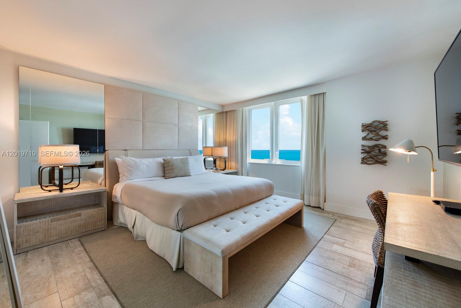 A bedroom with a king bed, ocean view, and light wood flooring — 102 24th St # 1012, Miami Beach FL 33139, MIAMI BEACH, FL
