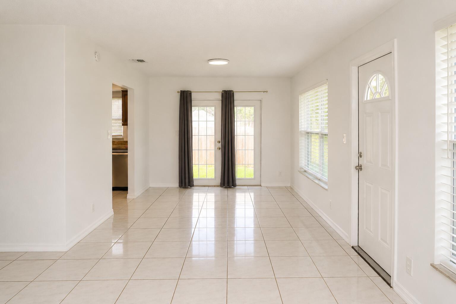 A bright dining area features white walls, light tile flooring, a glass door, and windows — 92 Lariat Circle, Boca Raton FL 33487, BOCA RATON, FL
