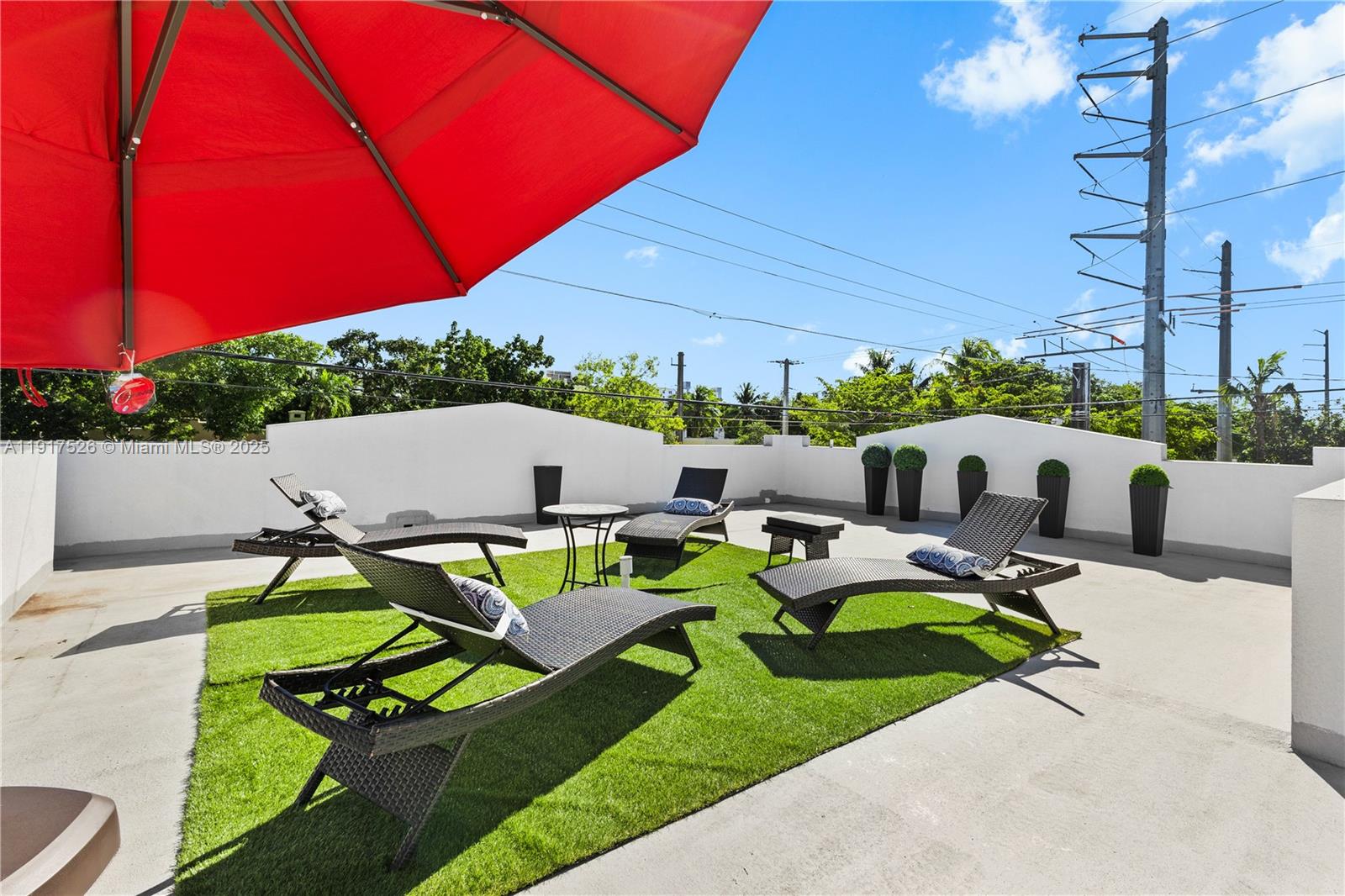 A rooftop terrace features artificial turf, lounge chairs, and a large red umbrella — 305 NW 58th St, Miami FL 33127, MIAMI, FL