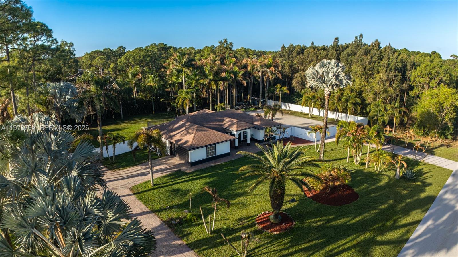 An aerial view shows a single-story house surrounded by a large lawn and palm trees — 15780 N 75th Ln N, Loxahatchee FL 33470, LOXAHATCHEE, FL