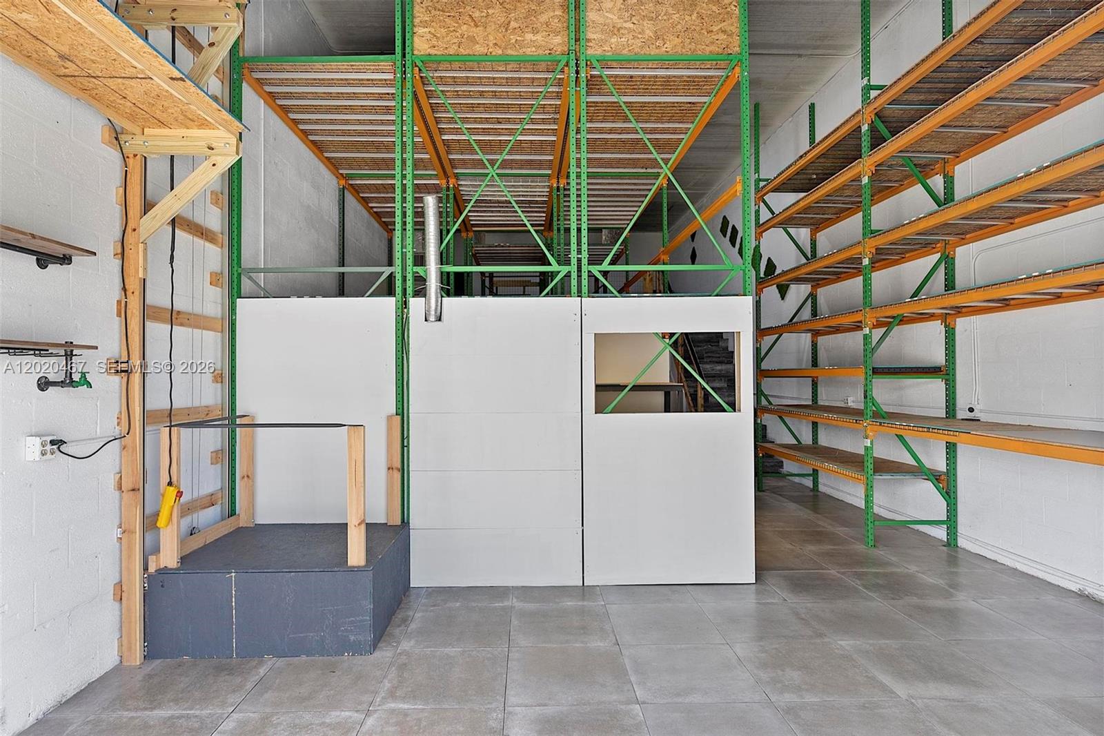 A warehouse interior features industrial metal shelving, a raised storage platform, and a small enclosed office — 1773 Blount Rd # 311, Pompano Beach FL 33069, POMPANO BEACH, FL