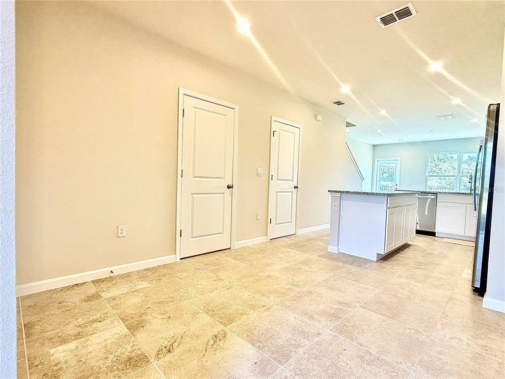 A kitchen and dining area with tile flooring, white cabinets, and a central island — 1188 PORT BLUE WAY, LADY LAKE, FL