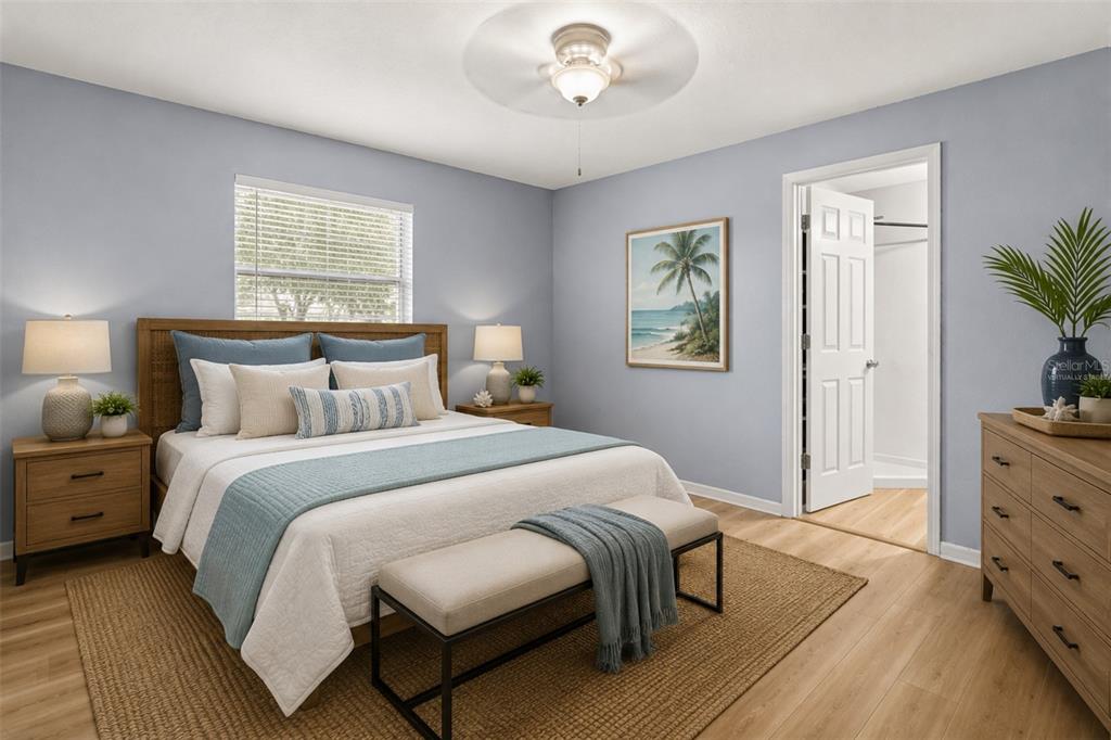 A bedroom features a bed with blue bedding, a wooden dresser, and light-colored wood flooring — 3469 JANET STREET, APOPKA, FL