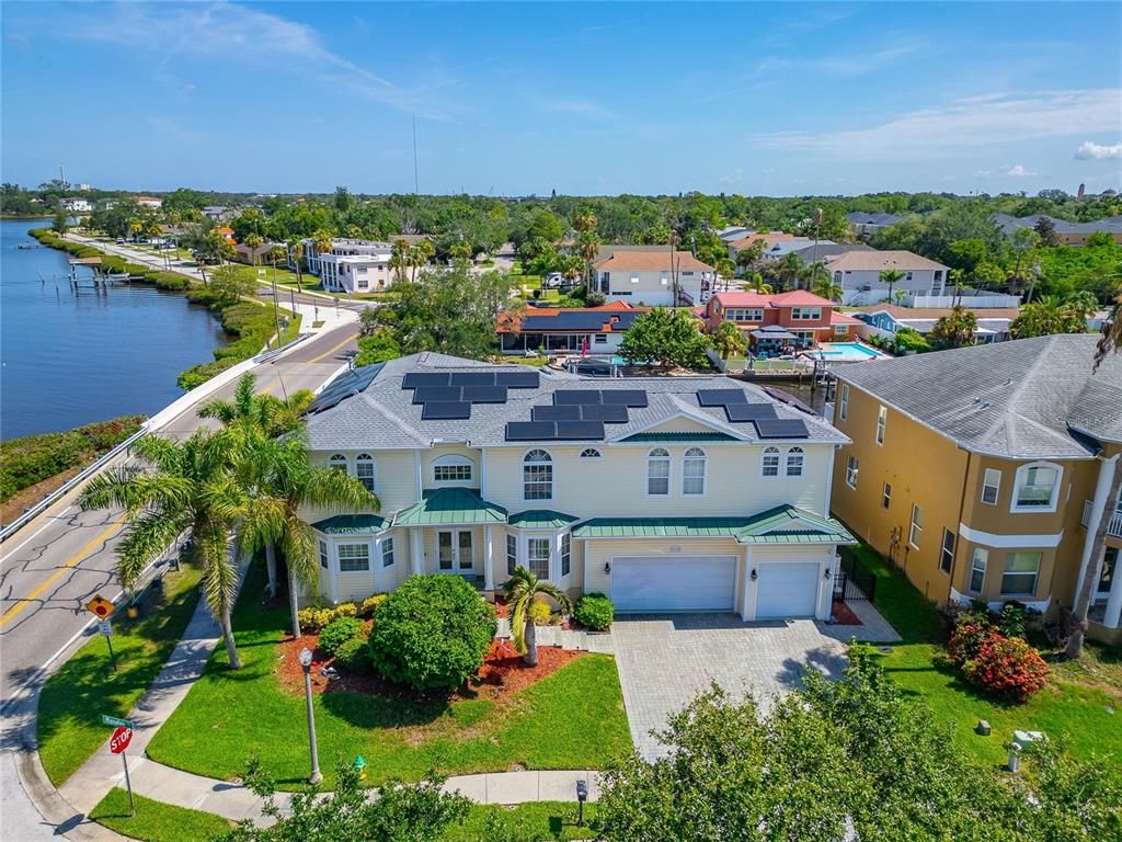 An aerial view of a two-story yellow house with solar panels on the roof — 339 MANATEE LANE, TARPON SPRINGS, FL