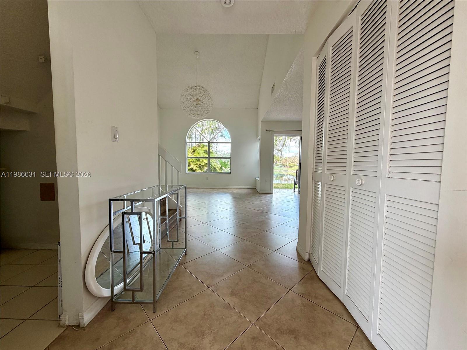 A tiled entryway leads to a living area with a large arched window and patio — 12619 NW 11th Pl, Sunrise FL 33323, SUNRISE, FL