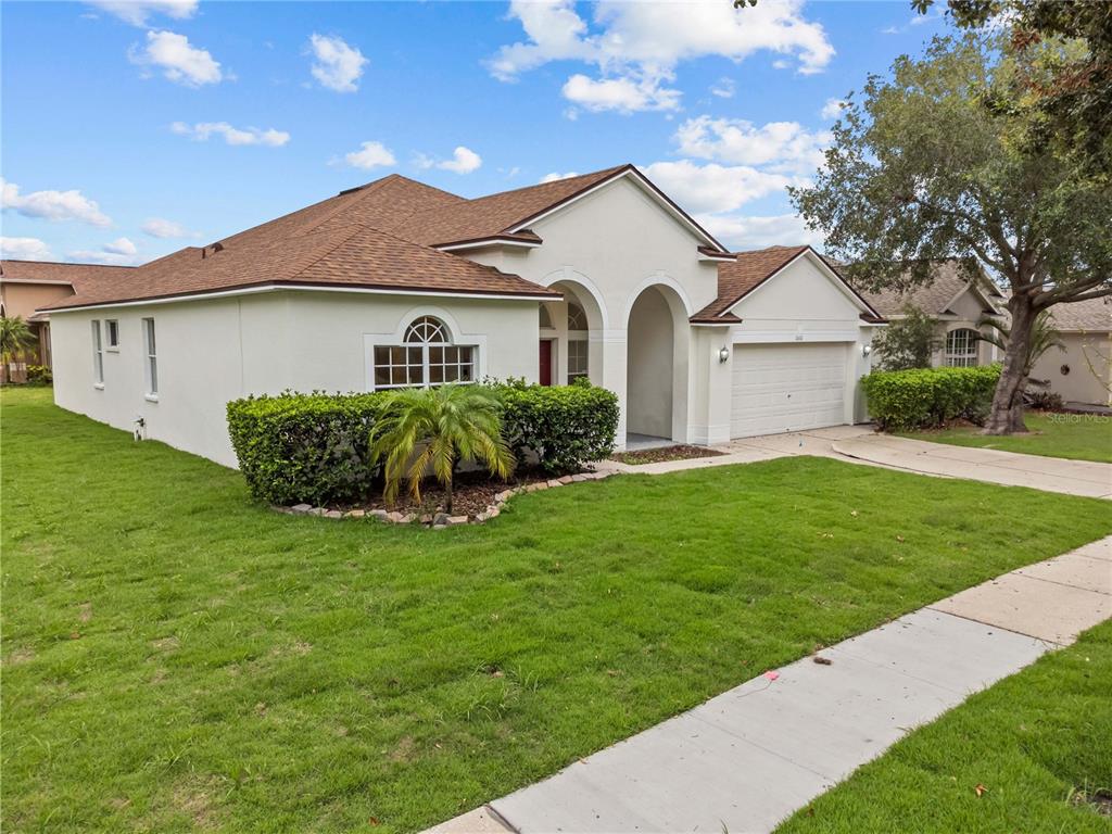 A single-story house with a white stucco exterior, a brown roof, and a two-car garage — 11611 JORDANS LANDING COURT, RIVERVIEW, FL