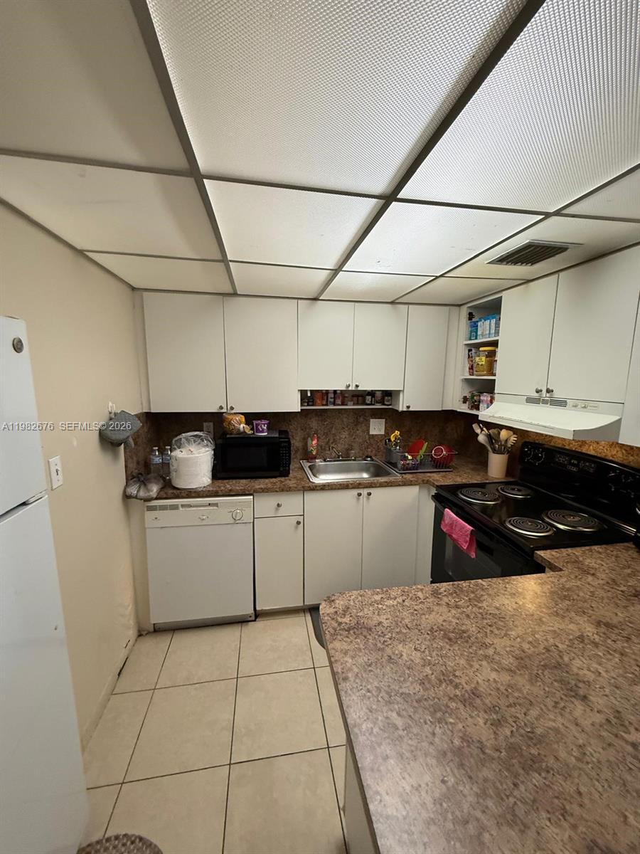 A kitchen features white cabinets, a brown countertop, a dishwasher, and a drop ceiling — 2029 NW 46th Ave # E305, Lauderhill FL 33313, LAUDERHILL, FL