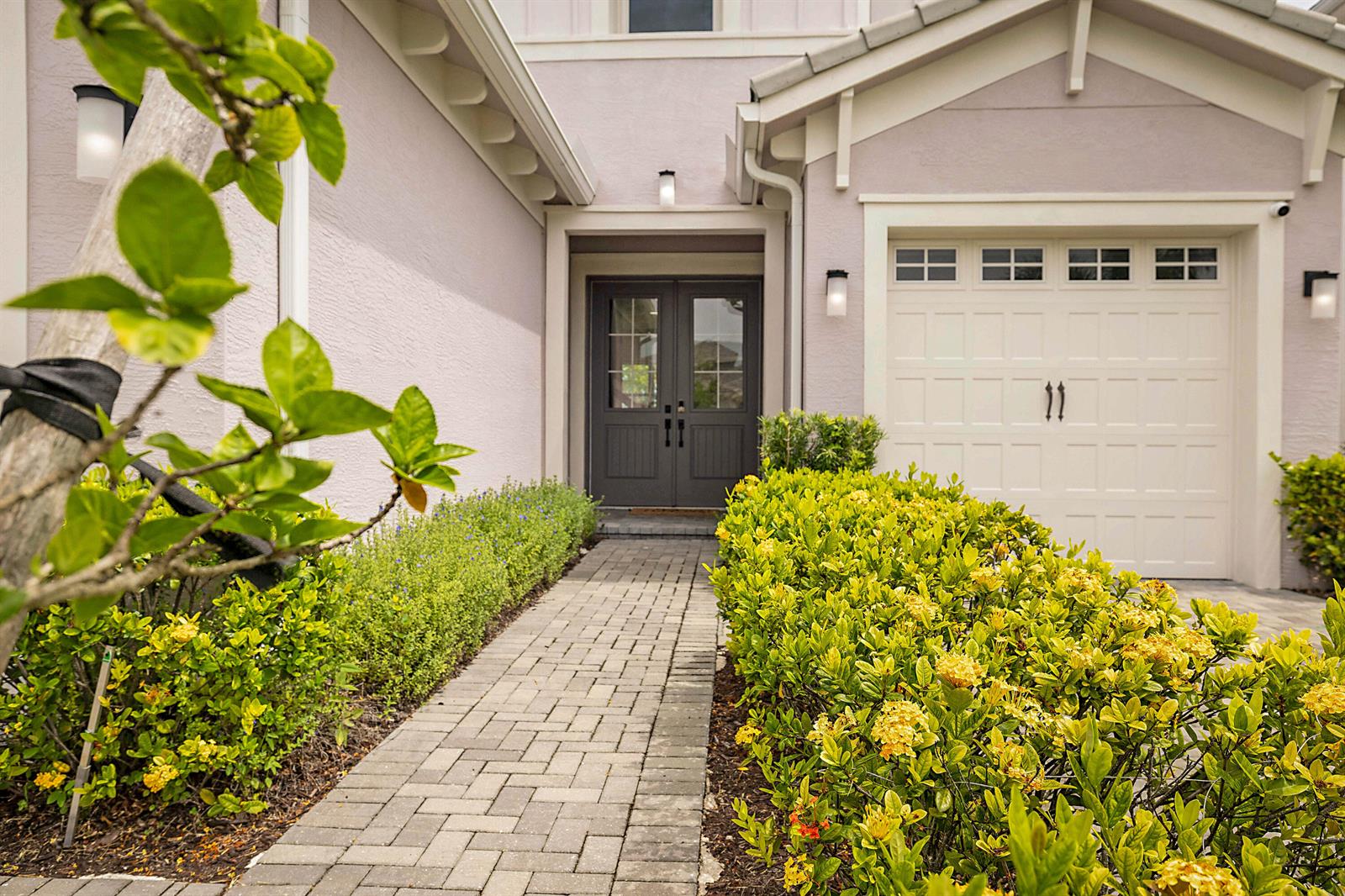 A stone walkway leads to the dark double front doors of a light-colored suburban home — 16088 Orchard Drive, FL 33470, FL