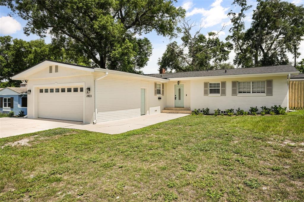 A single-story house with a white exterior, a two-car garage, and a light green front door — 2803 RIDDLE DRIVE, WINTER PARK, FL