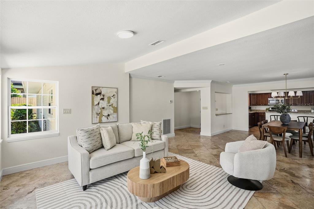 A living room with tile floors, a beige sofa, and an adjacent dining area — 2803 RIDDLE DRIVE, WINTER PARK, FL
