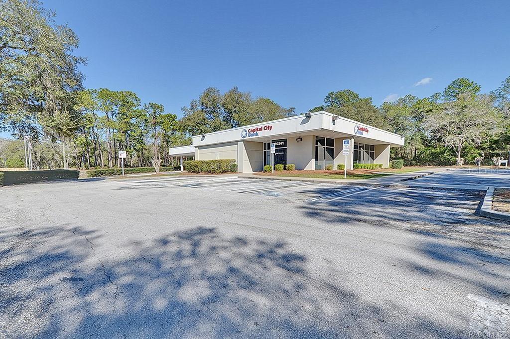 A single-story Capital City Bank building stands in a paved parking lot surrounded by trees — 10241 N FLORIDA AVENUE, CITRUS SPRINGS, FL