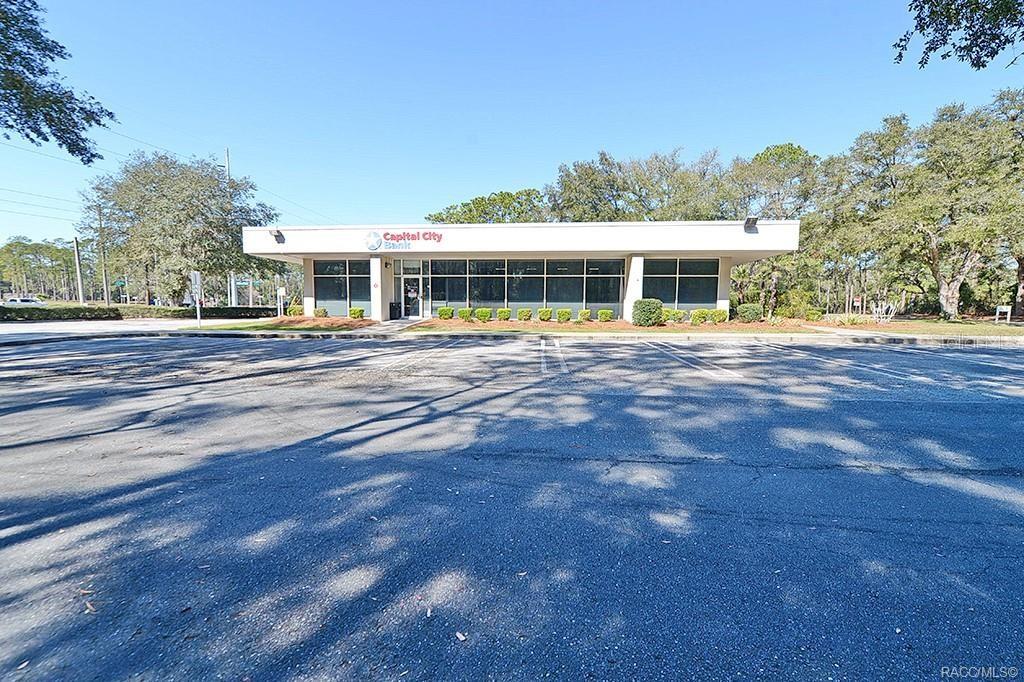 A single-story Capital City Bank building sits behind a large, empty asphalt parking lot — 10241 N FLORIDA AVENUE, CITRUS SPRINGS, FL