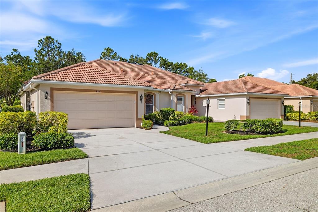A single-story suburban house with a tile roof, two garage doors, and a concrete driveway — 4316 CALLISTA LANE, SARASOTA, FL