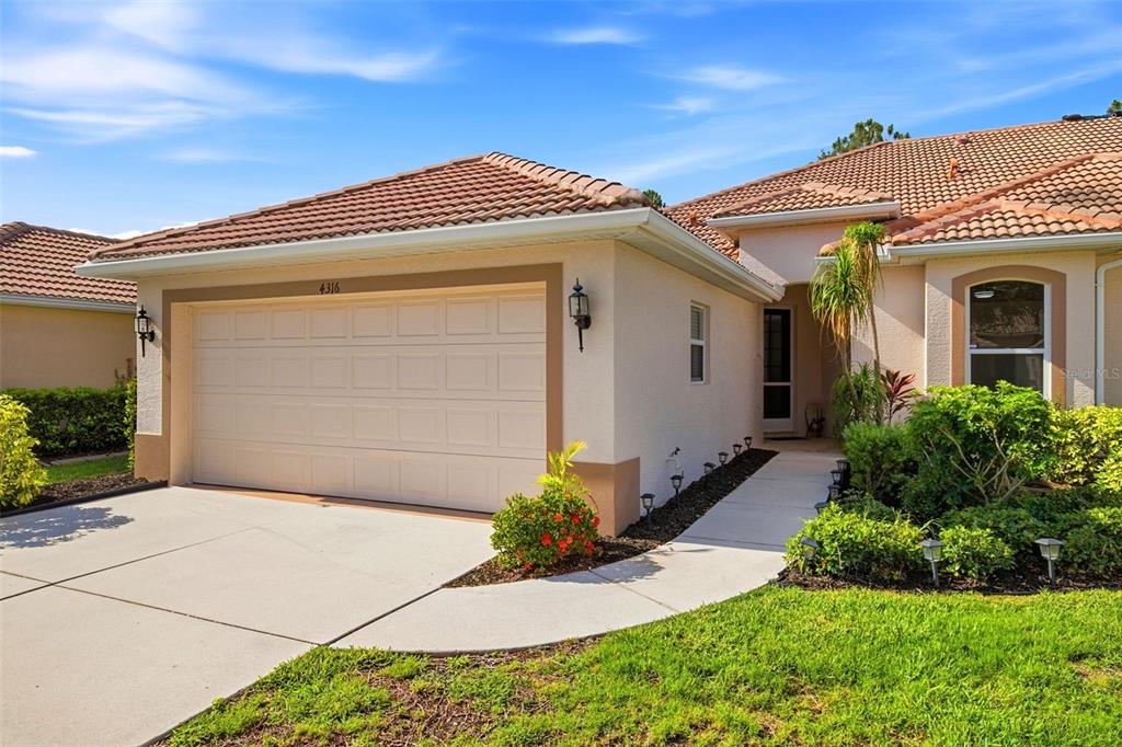 A single-story house exterior features a two-car garage, a tiled roof, and a front walkway — 4316 CALLISTA LANE, SARASOTA, FL