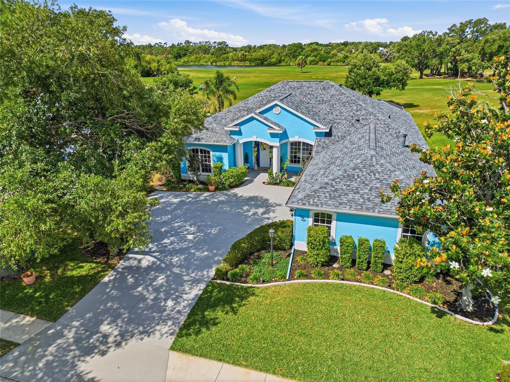 An aerial view of a bright blue house with a gray roof and a driveway — 758 PLANTERS MANOR WAY, BRADENTON, FL
