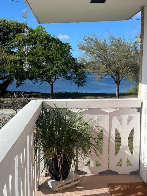 A view of a lake from a white concrete balcony featuring a potted plant — 2020 Lake Osborne Drive # 11, FL 33461, FL