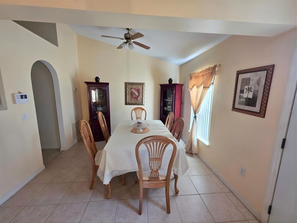 A dining room with a table, six chairs, two cabinets, and a ceiling fan — 907 STOCKPORT DRIVE, KISSIMMEE, FL
