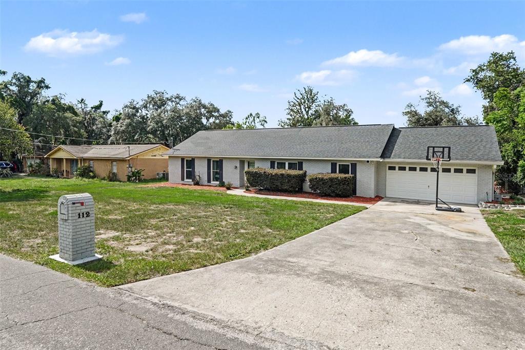 A single-story brick house with a two-car garage and a basketball hoop in the driveway — 112 W BRENTRIDGE DRIVE, BRANDON, FL
