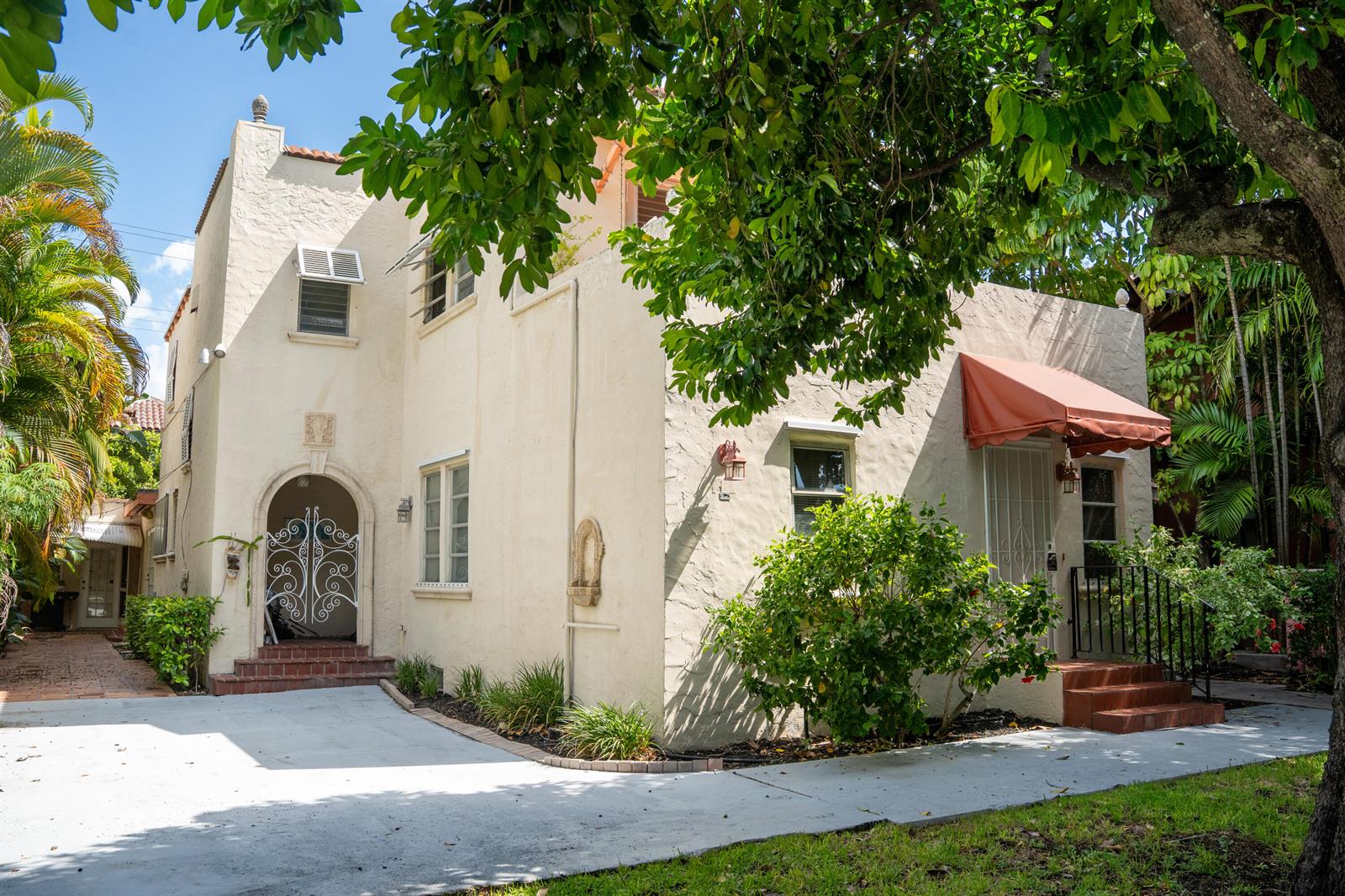 A two-story stucco building with an arched entryway, a red awning, and a concrete driveway — 219 Seminole Avenue, Palm Beach FL 33480, PALM BEACH, FL