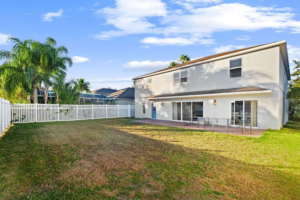 The exterior of a two-story house features a large backyard with a white fence — 1349 CASTLEPORT ROAD, WINTER GARDEN, FL