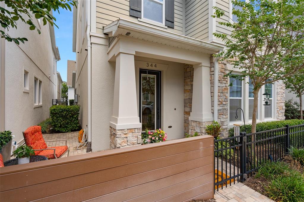 The exterior of a house features a covered porch, stone pillars, and a small patio — 344 WHEELHOUSE LANE, LAKE MARY, FL