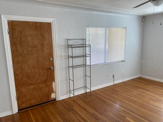 A room with hardwood floors, a wooden door, a metal shelving unit, and a window — 888 14TH AVENUE S, ST PETERSBURG, FL