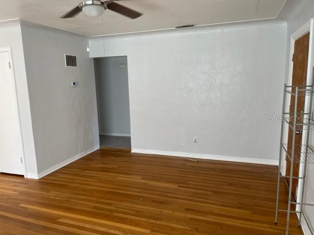 An empty room features light gray walls, hardwood flooring, and a ceiling fan — 888 14TH AVENUE S, ST PETERSBURG, FL