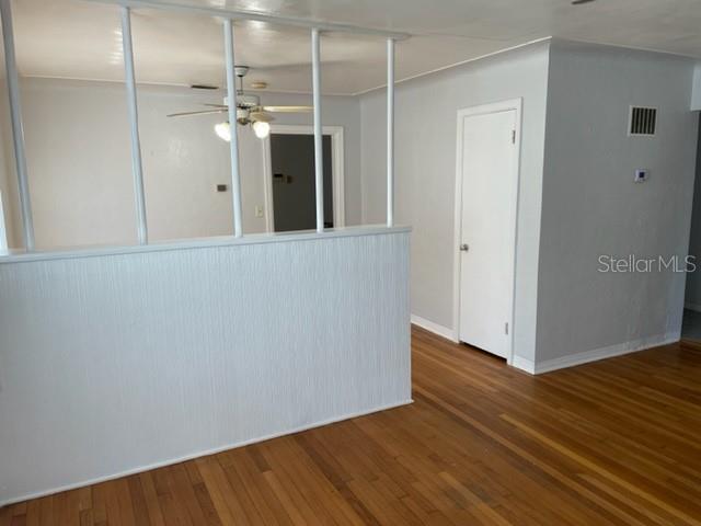 An interior view shows a room with hardwood floors, a partial wall divider, and a door — 888 14TH AVENUE S, ST PETERSBURG, FL
