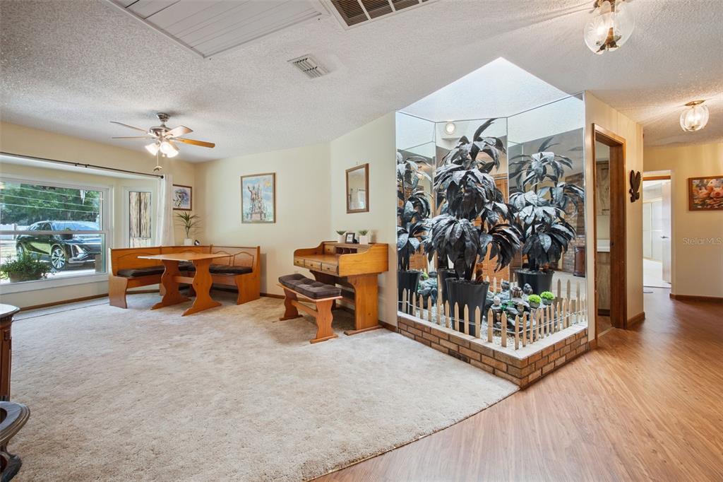 A room with carpet, a wooden breakfast nook, a desk, and an indoor mirrored planter — 7232 E TURNER CAMP ROAD, INVERNESS, FL