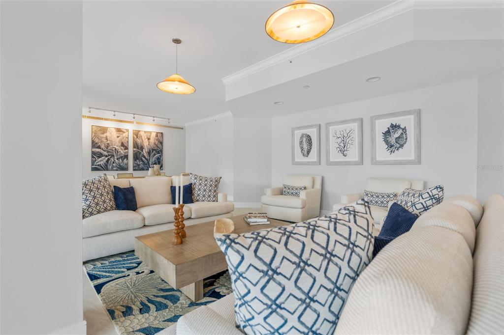 A living room features white sofas, patterned accent pillows, a wooden coffee table, and coastal artwork — 1050 LONGBOAT CLUB ROAD UNIT 506, LONGBOAT KEY, FL