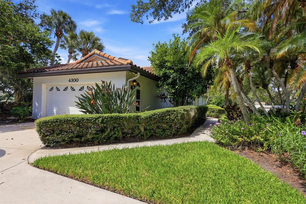 A single-story house with a white exterior, a tiled roof, and a manicured hedge — 4300 CAMINO MADERA, SARASOTA, FL