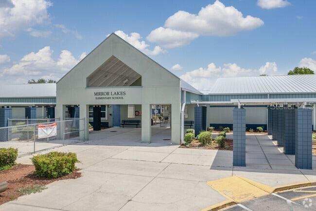 The exterior of Mirror Lakes Elementary School features a covered entrance and a metal roof — 608 CHEMSTRAND STREET E, LEHIGH ACRES, FL