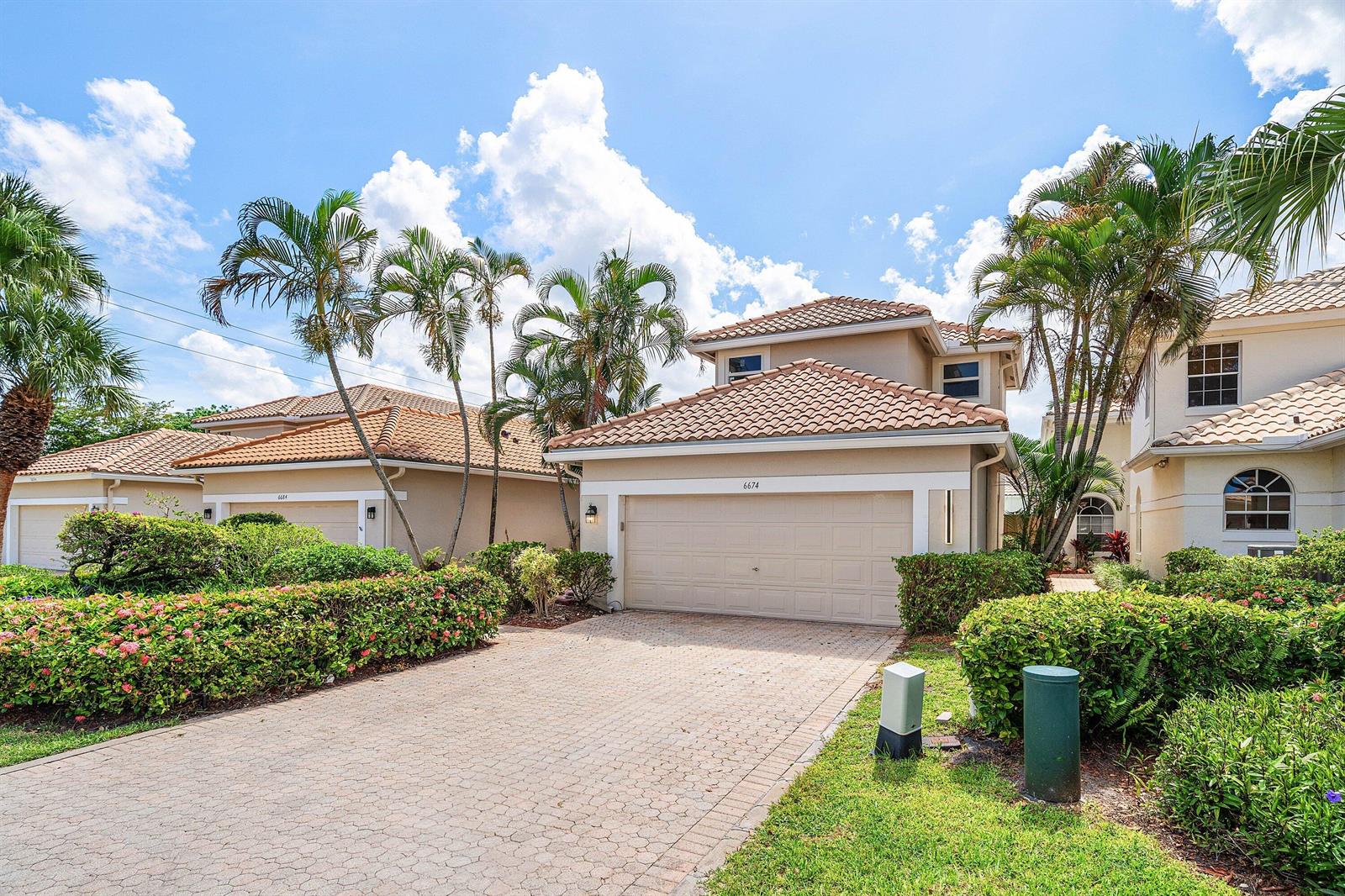 A two-story house with a beige exterior, a tiled roof, and a paved driveway — 6674 NW 25th Avenue, Boca Raton FL 33496, BOCA RATON, FL