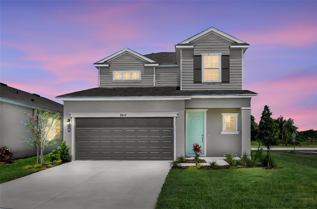 A two-story suburban house with a gray exterior, a two-car garage, and a teal front door — 7839 GLEN LILY PLACE, PARRISH, FL