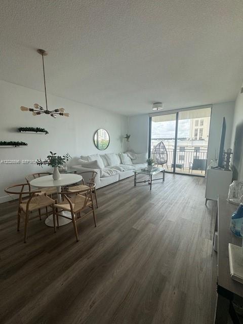 A living and dining area features light wood-look flooring, a white sofa, and balcony access — 1300 Ponce De Leon Blvd # 702, Coral Gables FL 33134, CORAL GABLES, FL