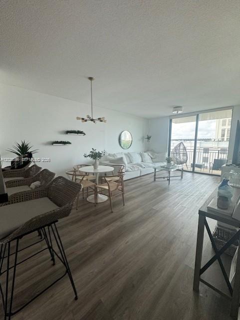 A living room features light wood-look flooring, a white sectional sofa, and a dining area — 1300 Ponce De Leon Blvd # 702, Coral Gables FL 33134, CORAL GABLES, FL