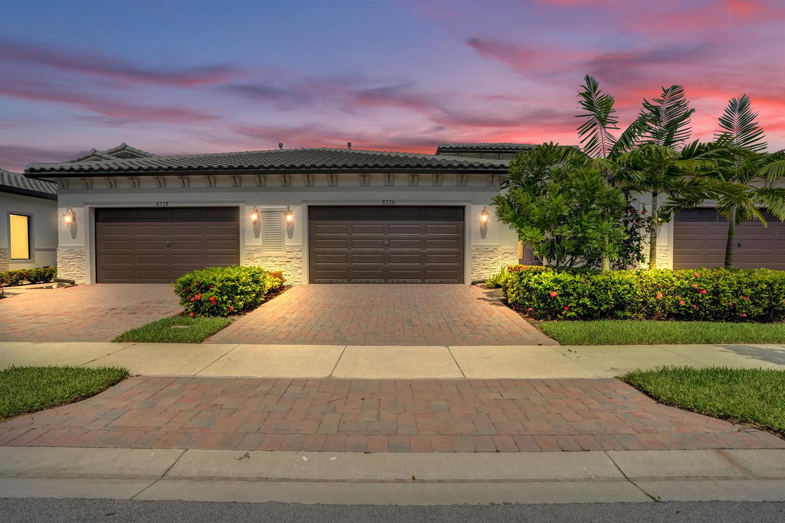 A residential building exterior features two brown garage doors, brick driveways, and landscaped bushes — 8336 W Blue Spring Drive, Parkland FL 33067, PARKLAND, FL