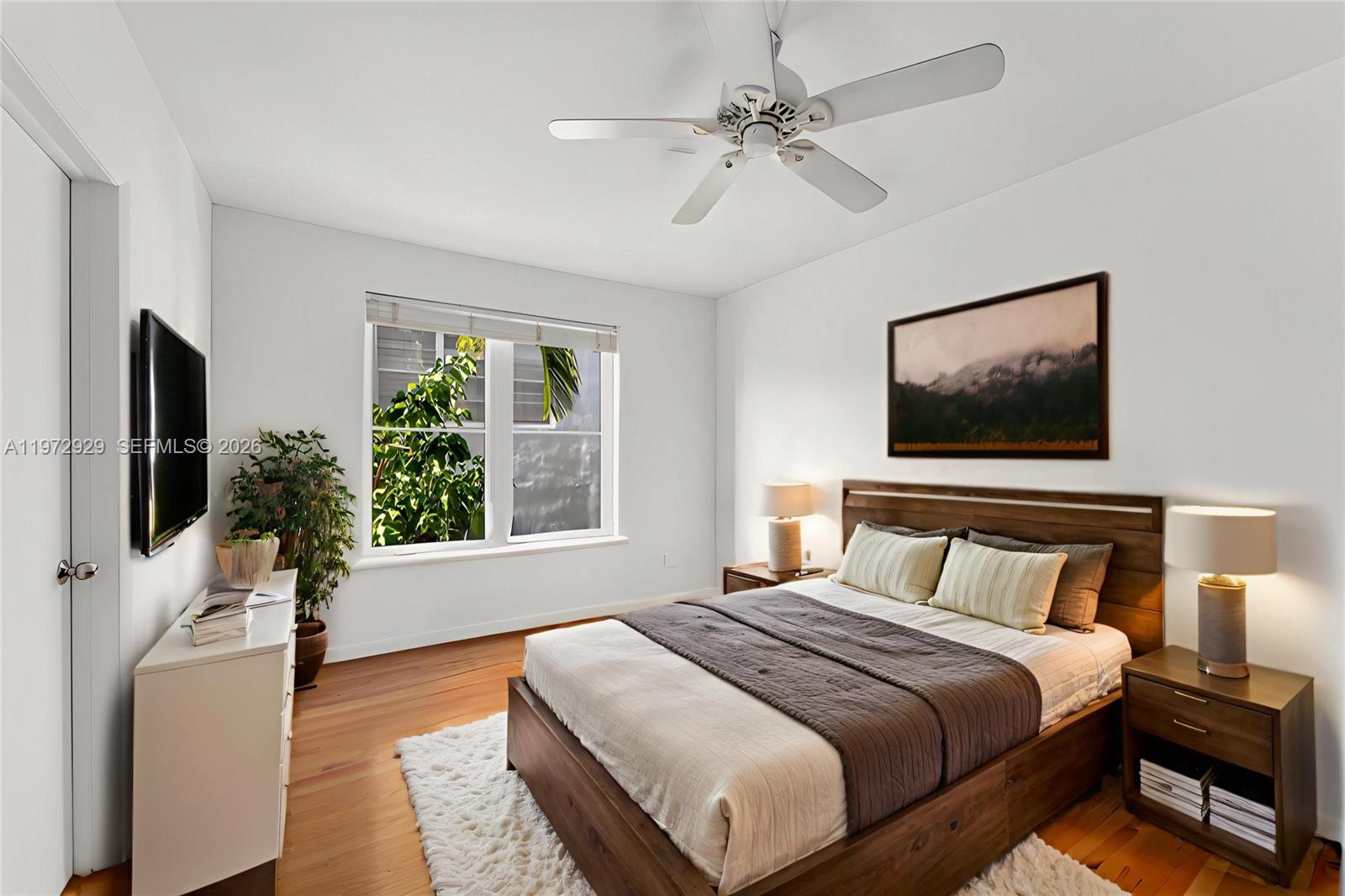 A bedroom features a wooden bed, white walls, hardwood floors, and a ceiling fan — 1018 Meridian Ave # 8, Miami Beach FL 33139, MIAMI BEACH, FL