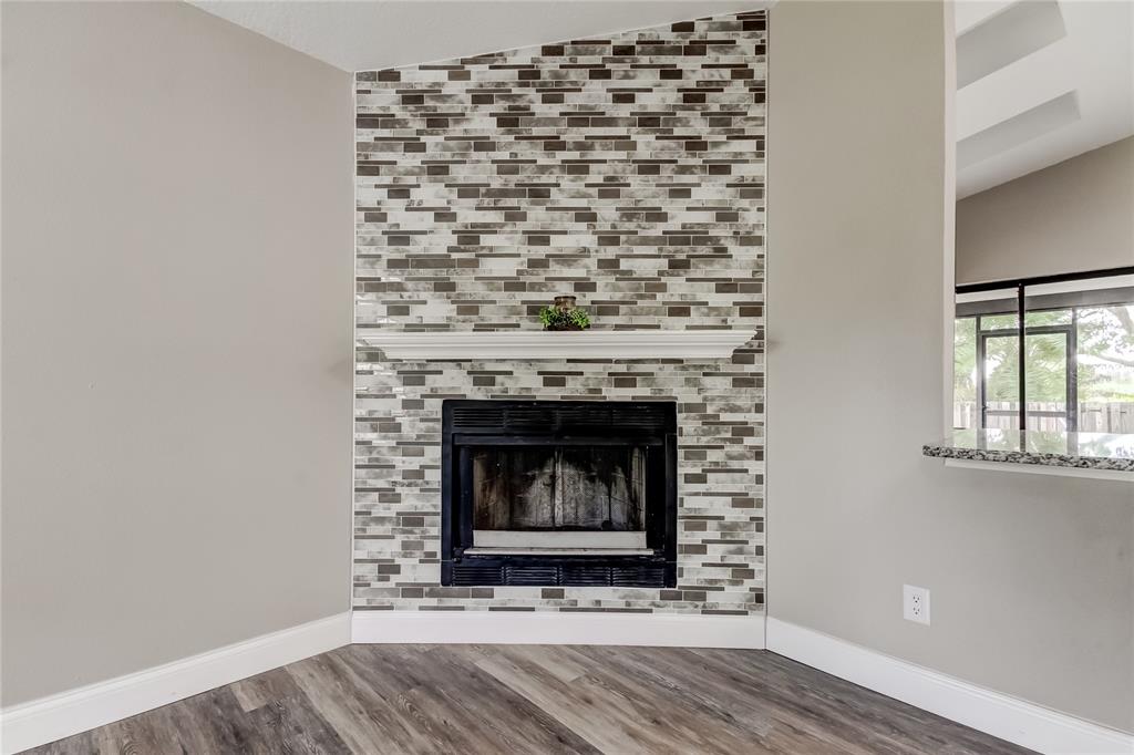 A corner fireplace features a white mantel and a multi-toned gray tiled surround — 206 BEDFORD STREET, OLDSMAR, FL