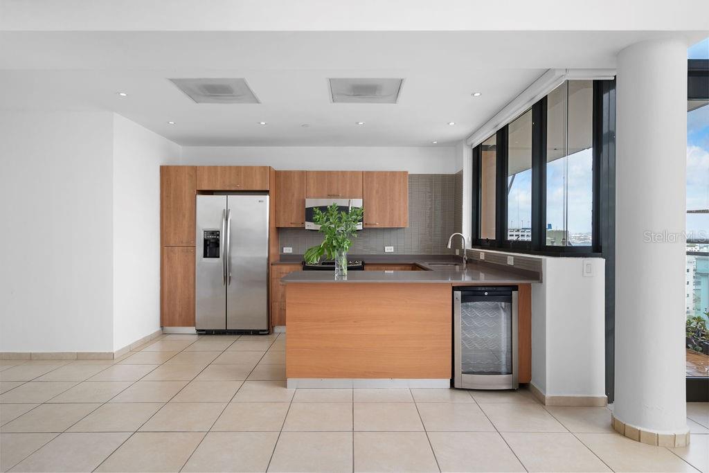 A modern kitchen features light wood cabinets, stainless steel appliances, and a wine refrigerator — 1511 PONCE DE LEON AVENUE UNIT PH-481, SAN JUAN, PR