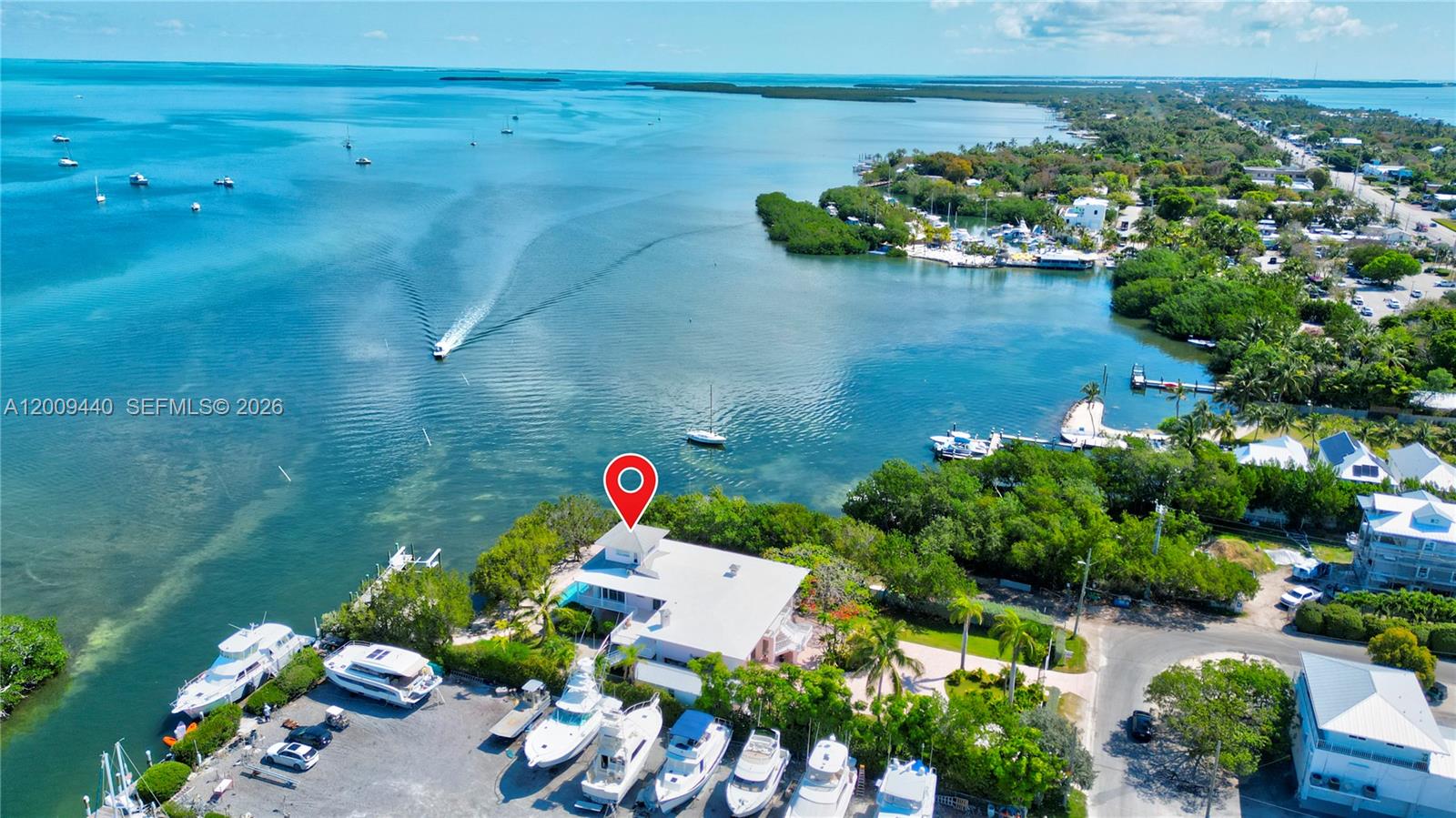 An aerial view shows a waterfront property with multiple docked boats and lush vegetation — 1101 Mastic Street, Islamorada FL 33036, ISLAMORADA, FL